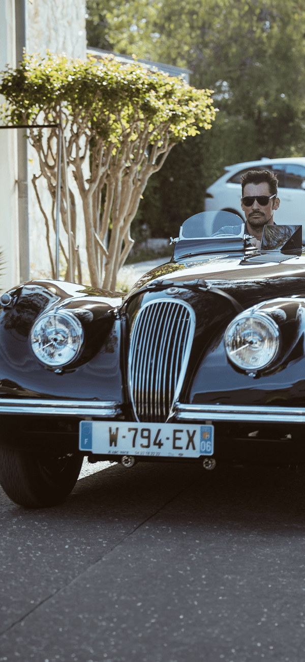 Classic black Jaguar convertible parked by the sea.