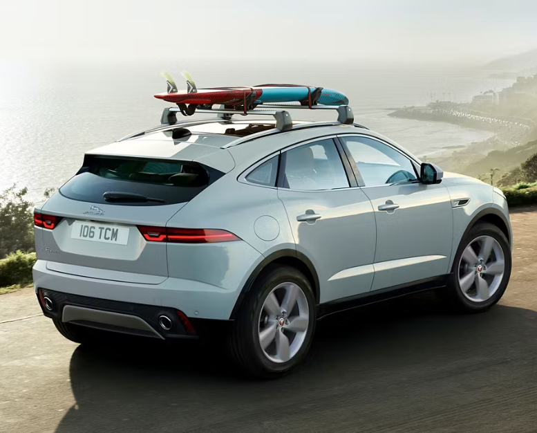 Roof rack on vehicle with surfboards attached by the coast.