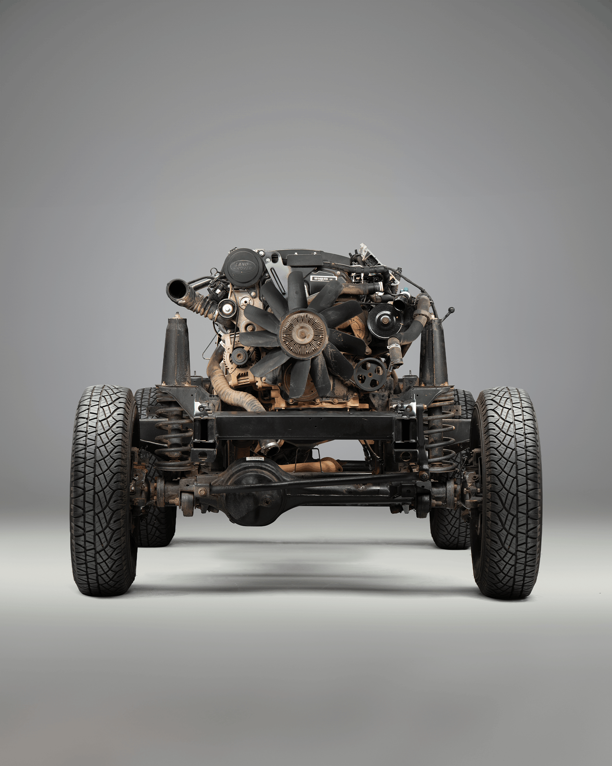 Front view of a black Defender with visible grille, headlights, and side mirror.