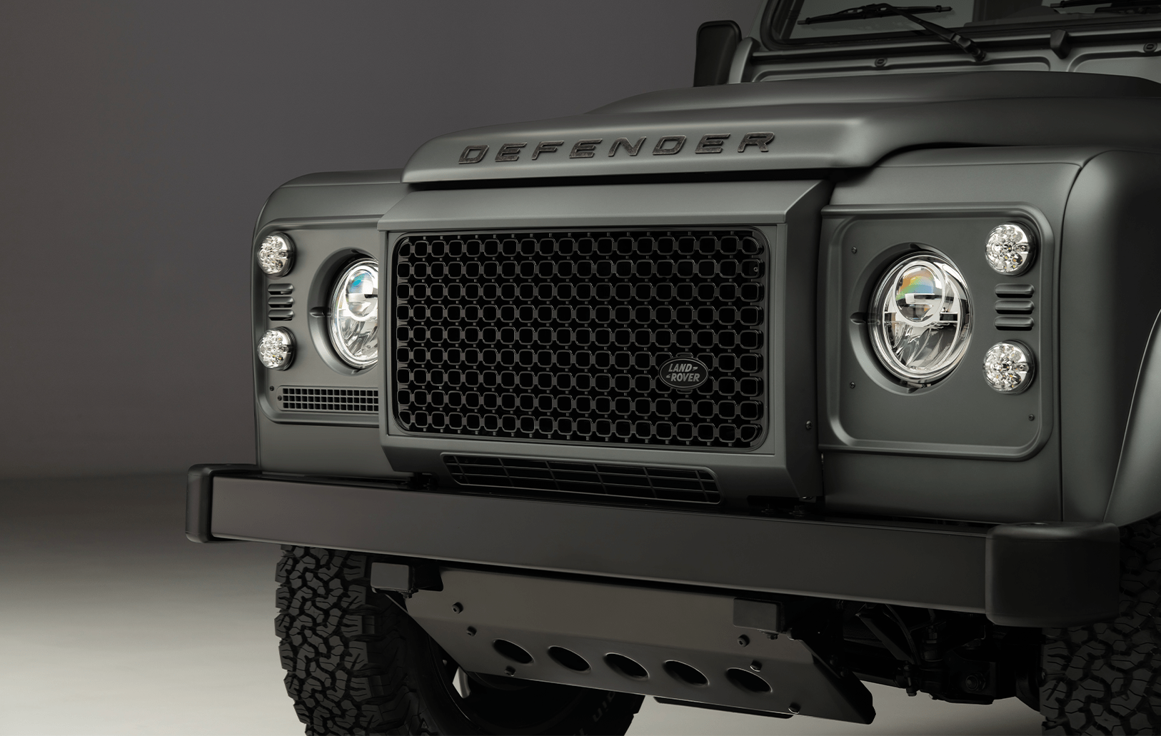 Soft Top Classic Defender on sandy ground.