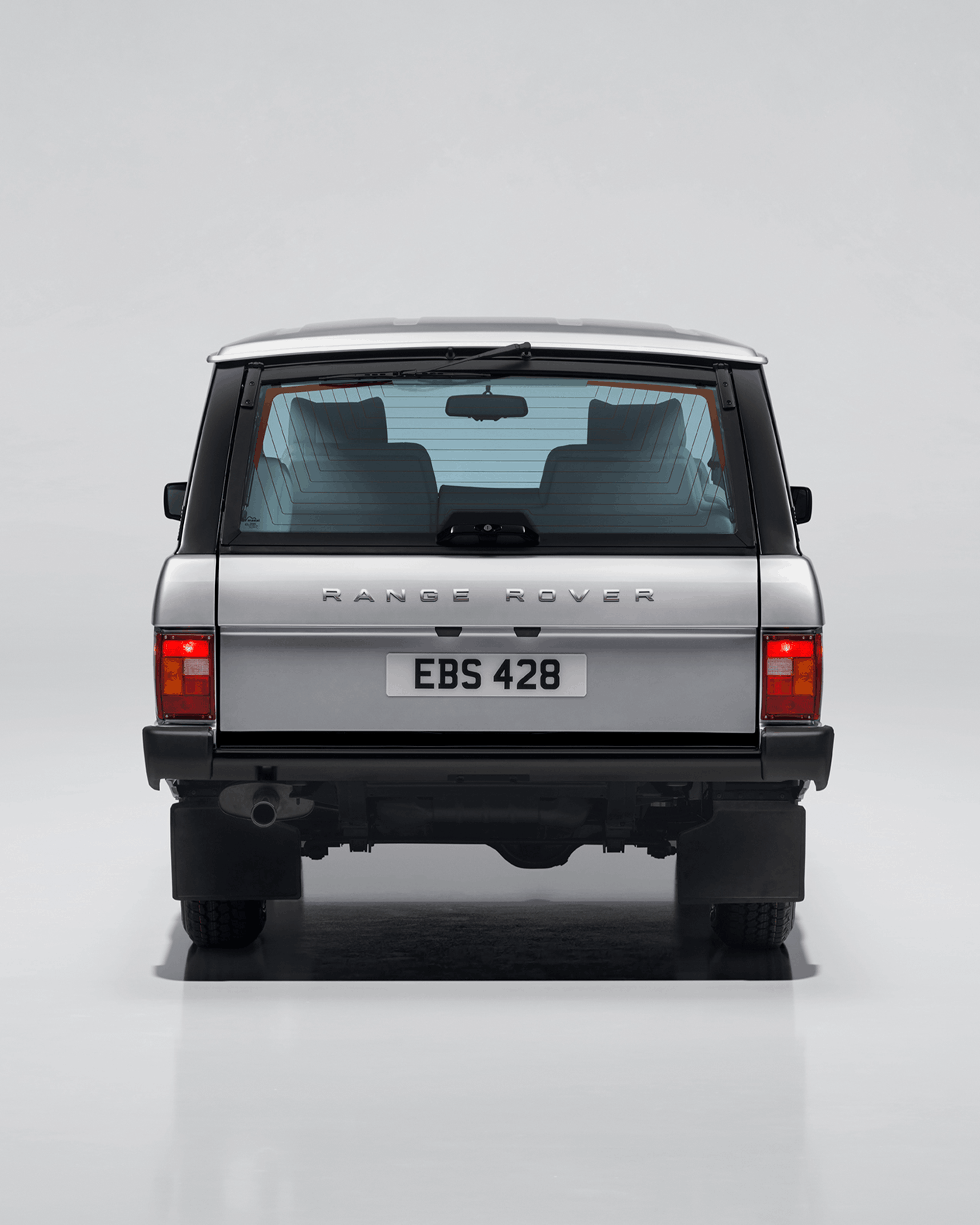 Front view of a black Defender with visible grille, headlights, and side mirror.