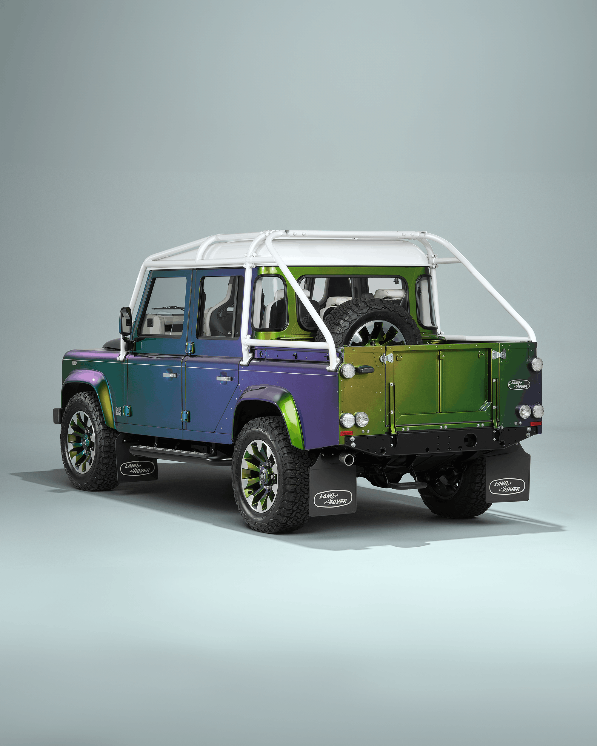 Front view of a black Defender with visible grille, headlights, and side mirror.
