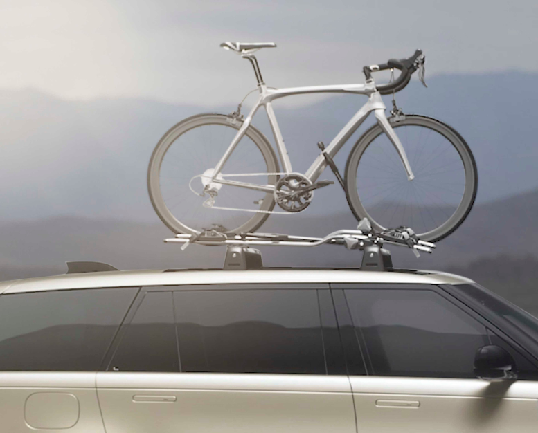 Vehicle with bike on roof in mountain setting.
