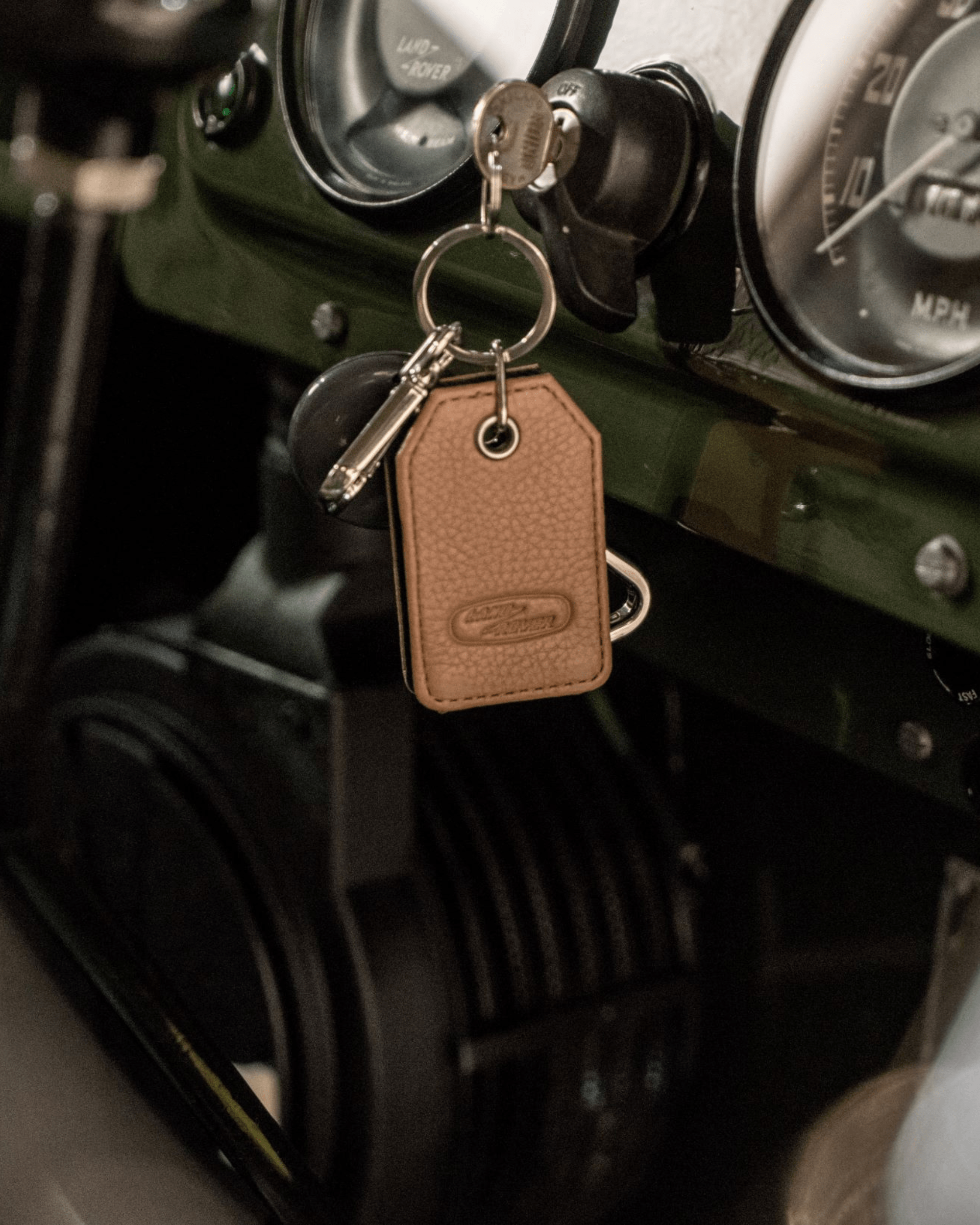 Close-up of dashboard with key in ignition and brown leather keychain.